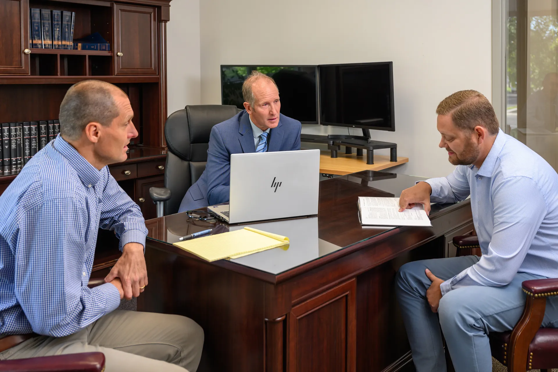 The three partners of Uintah Basin Law Group reviewing a case together